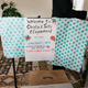 This is a photo of the backdrop people tuning into the livestream were presented. It says: Welcome to Christie and Jeff's elopement. Wash your hands. Mute your audio until we toast. Have a drink to toast.